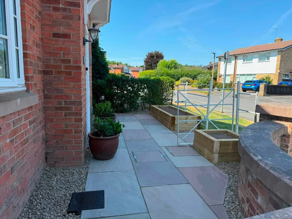 Indian sandstone front patio with sleeper raised planters and railings