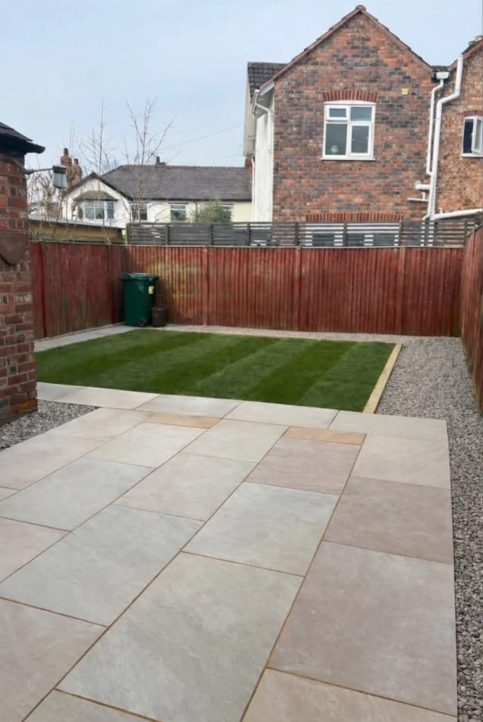 Garden makeover with sandstone patio, striped lawn, gravel edging and new fence