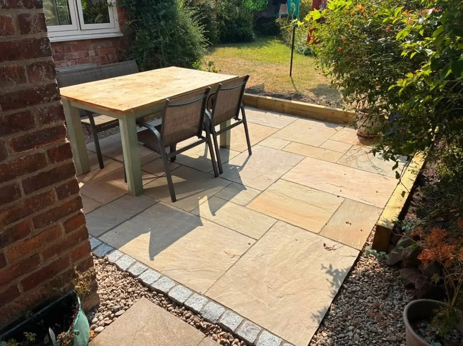 Sandstone patio with granite sett edging and garden dining table
