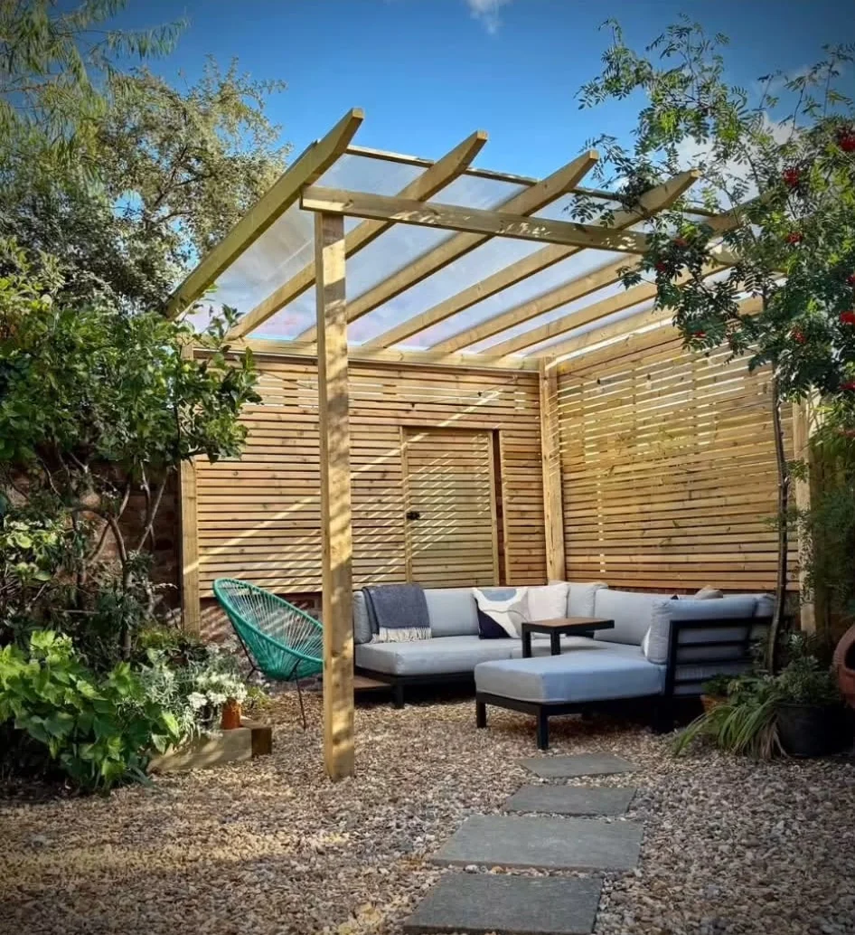 Timber pergola with clear roof over an outdoor seating area