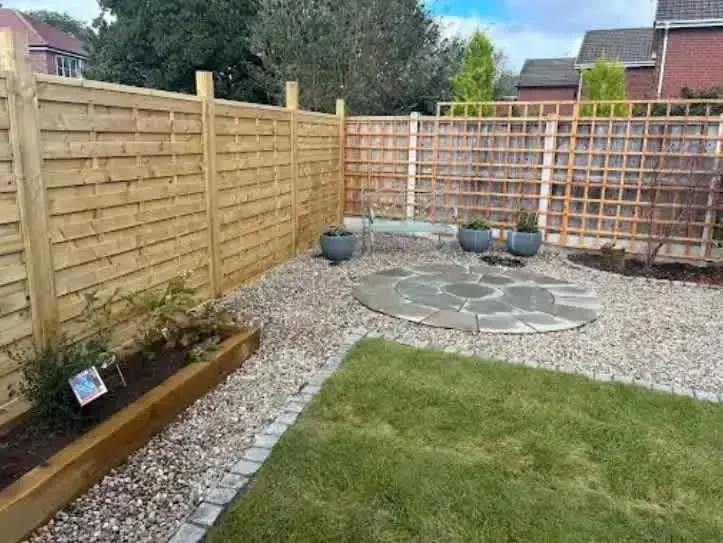 Landscaped garden with circular paving, gravel and trellis fencing by Chester Garden Services