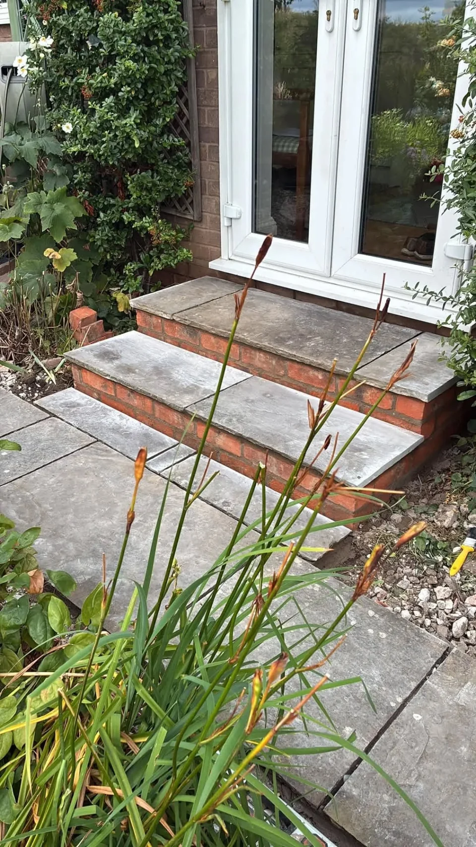 Hard landscaping with new stone steps and paving outside French doors