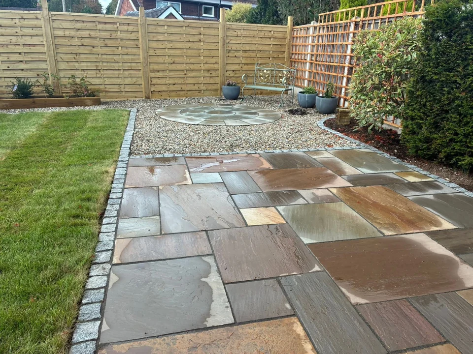 Patios & Paving in Chester. Indian sandstone patio with granite sett edging, lawn and gravel