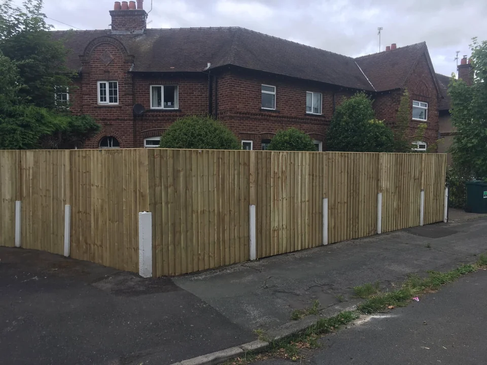 Long run of new close-board timber fencing along a driveway