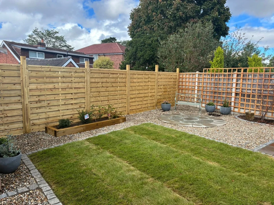 Back garden landscaping with lawn, gravel border and circular paved seating area