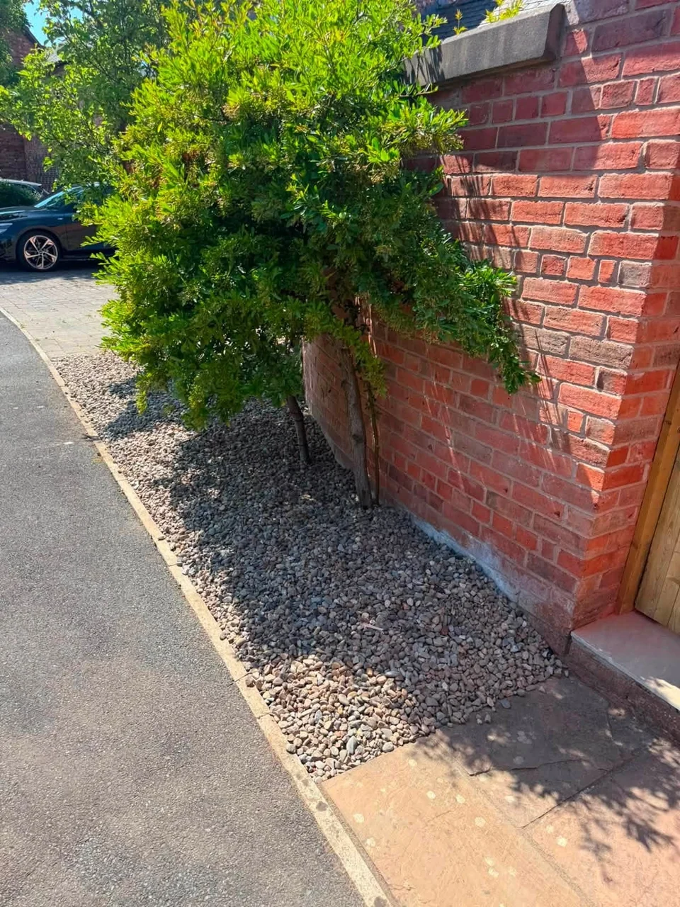 Resin Surfacing in Chester. Front garden hard landscaping with gravel border along a brick wall and paved path