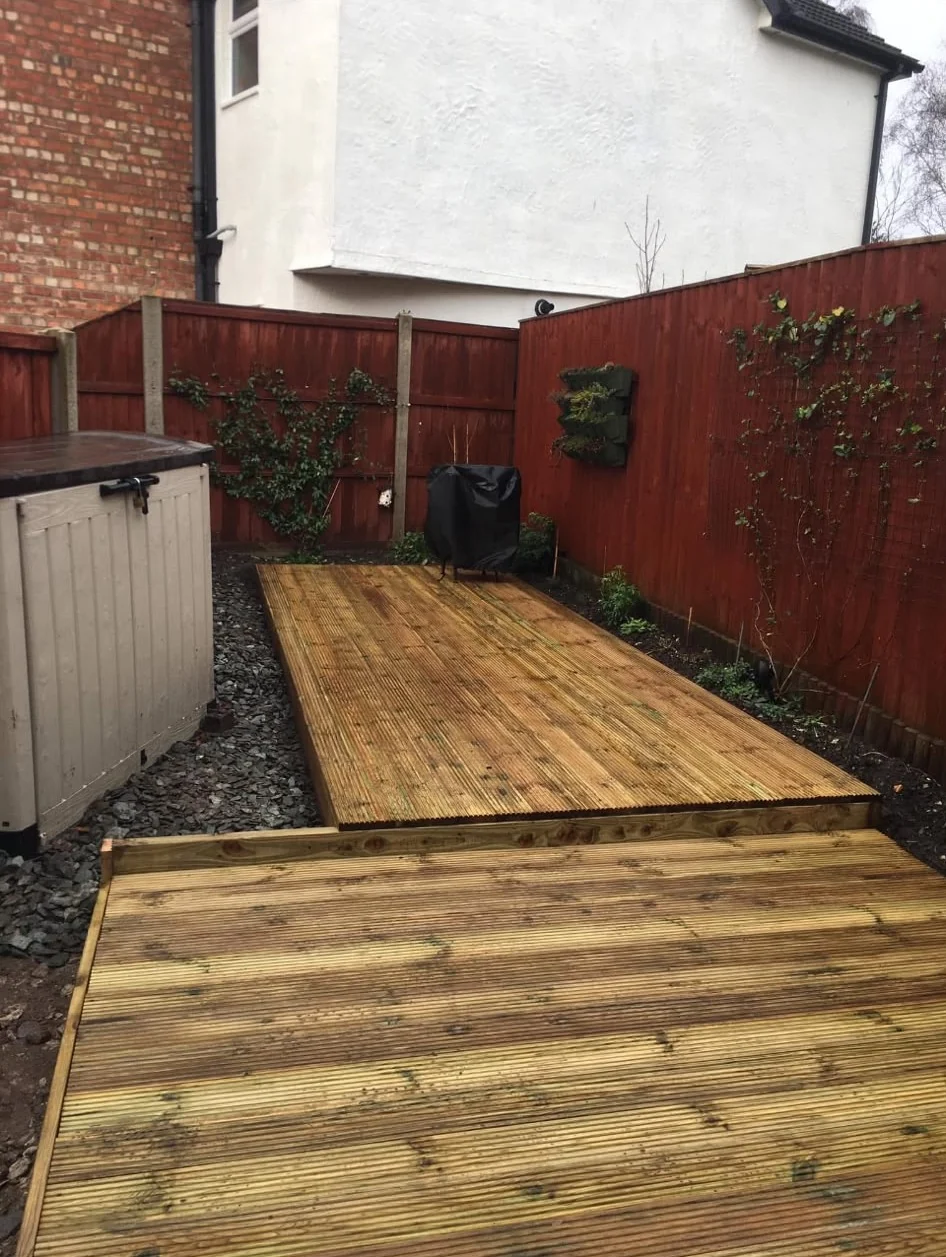 New timber decking in a fenced back garden